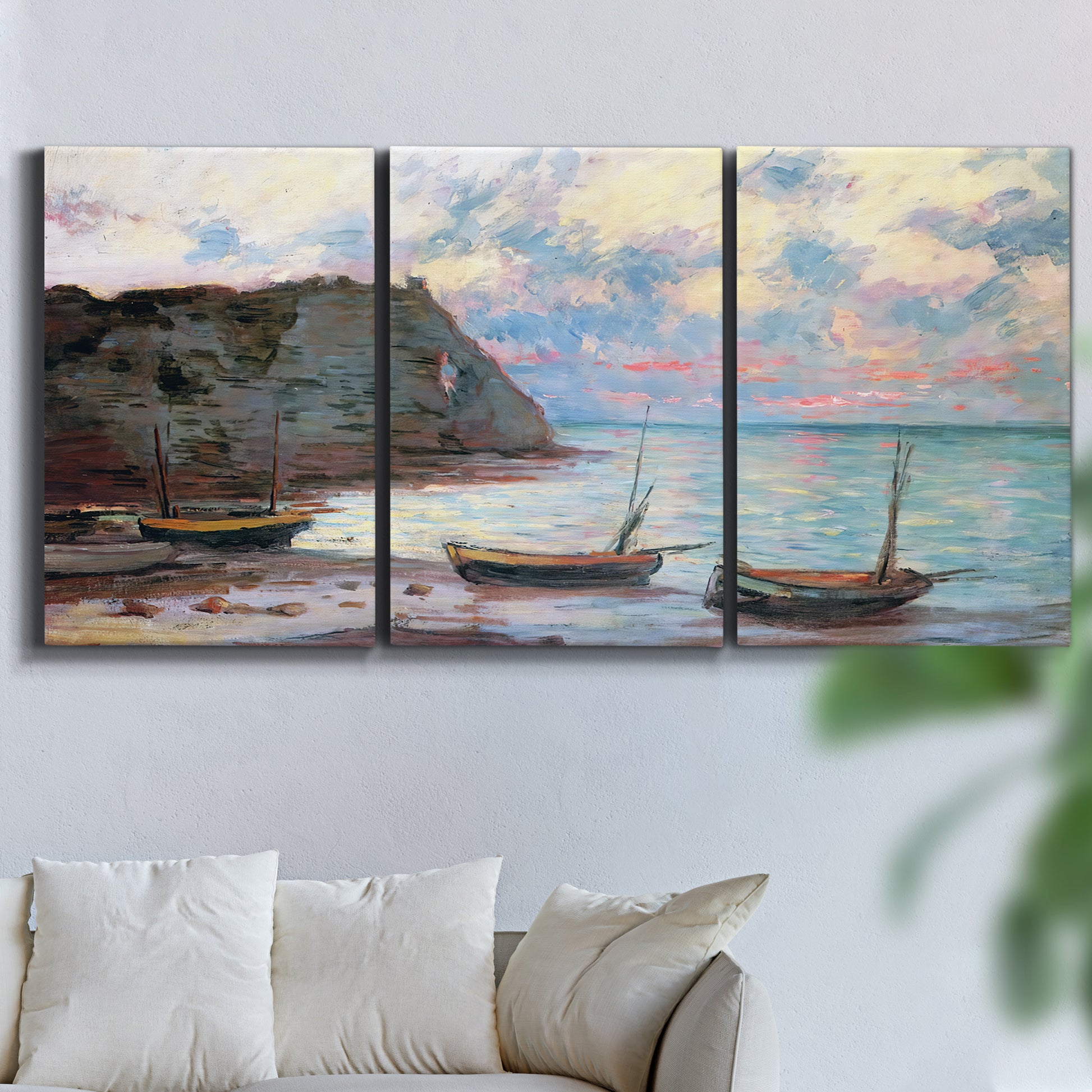 Three-panel canvas wall art featuring golden coastal sunset with cliffs, displayed in a living room above a sofa.