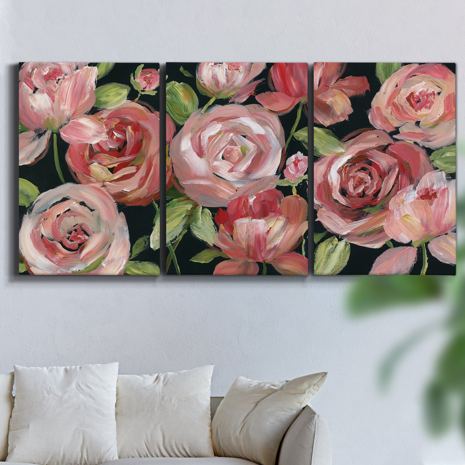 Three-panel canvas wall art featuring bold red floral abstraction, displayed in a living room above a sofa.