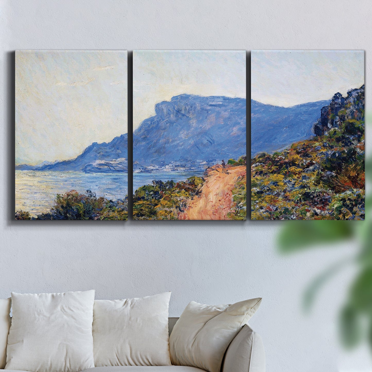 Three-panel canvas wall art featuring winding coastal road above sea, displayed in a living room above a sofa.