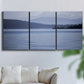 Three-panel canvas wall art featuring calm blue water landscape, displayed in a living room above a sofa.