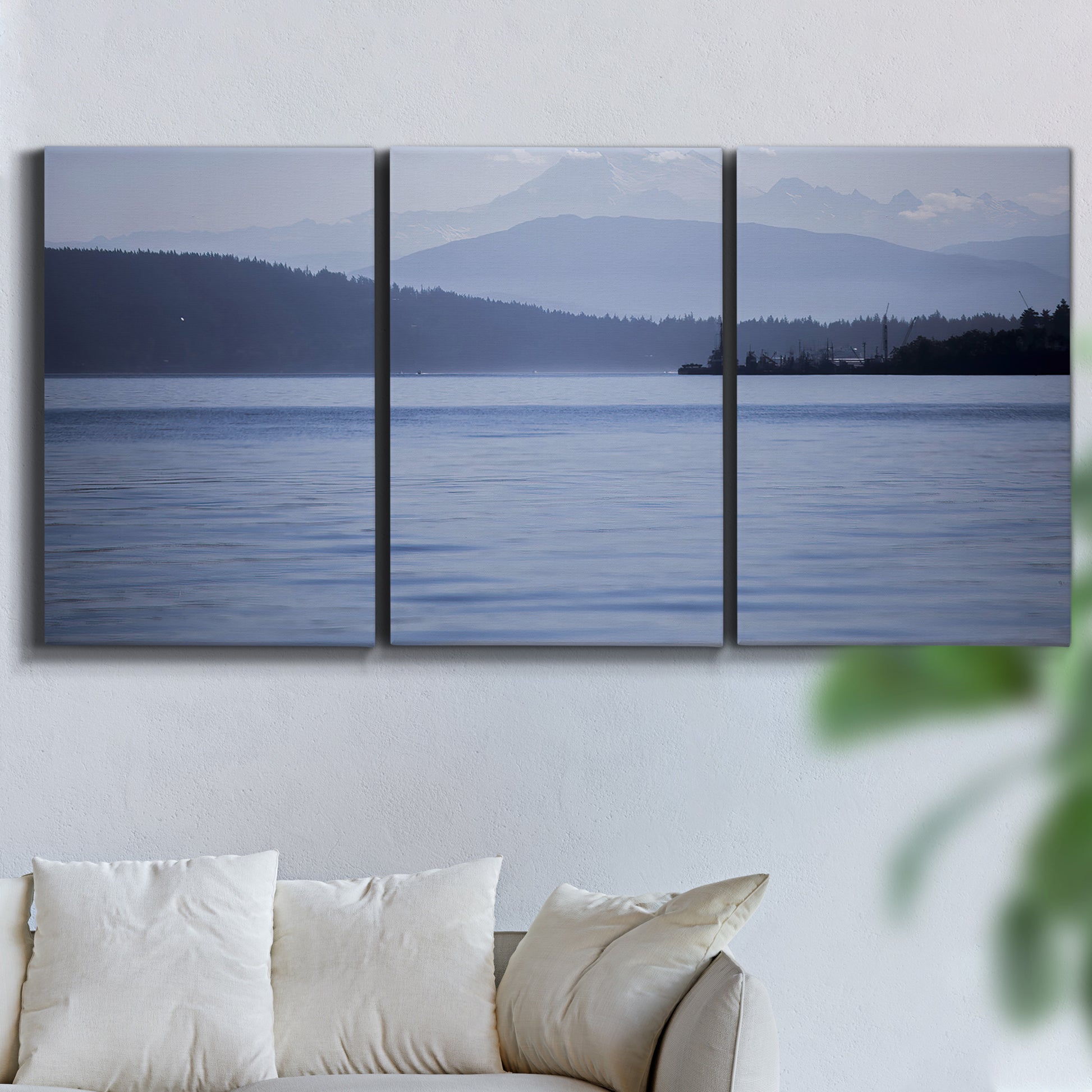 Three-panel canvas wall art featuring calm blue water landscape, displayed in a living room above a sofa.