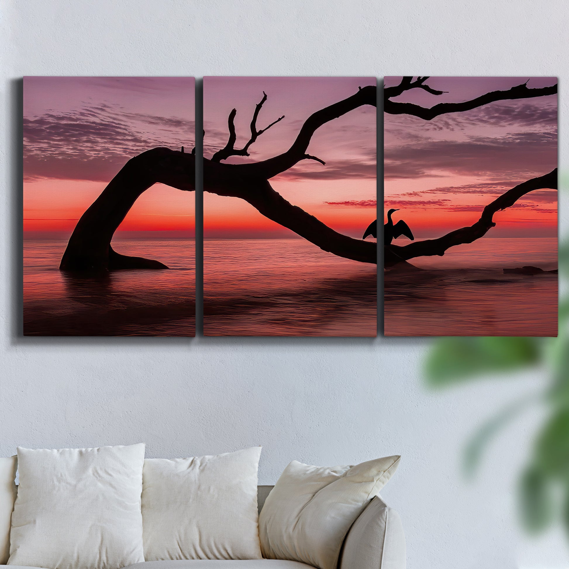 Three-panel canvas wall art featuring sunset beach photography, displayed in a living room above a sofa.