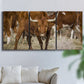 Three-panel canvas wall art featuring longhorn cattle standing together, displayed in a living room above a sofa.