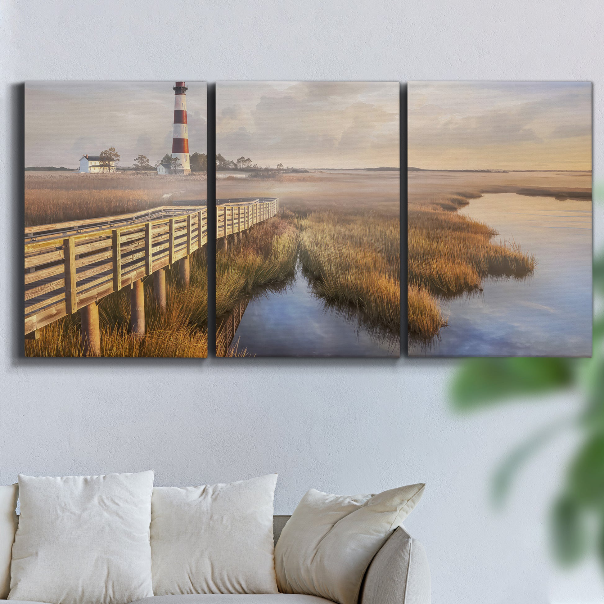 Three-panel canvas wall art featuring coastal path along dunes, displayed in a living room above a sofa.