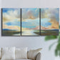 Three-panel canvas wall art featuring dawn light breaking over water, displayed in a living room above a sofa.