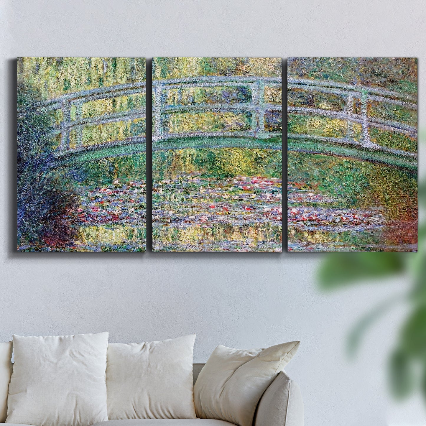 Three-panel canvas wall art featuring water lilies with arched bridge, displayed in a living room above a sofa.