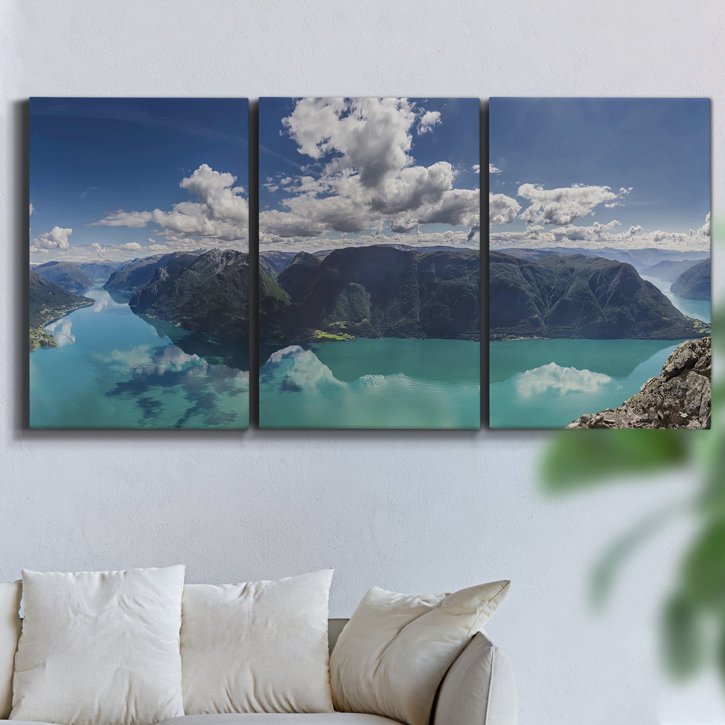 Three-panel canvas wall art featuring tropical water reflections with foliage, displayed in a living room above a sofa.