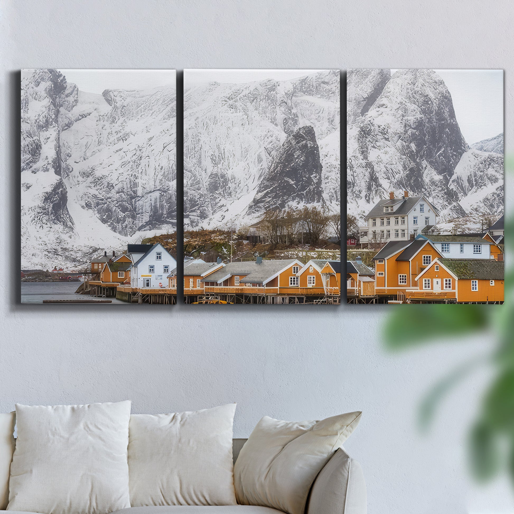 Three-panel canvas wall art featuring winter village street photography, displayed in a living room above a sofa.