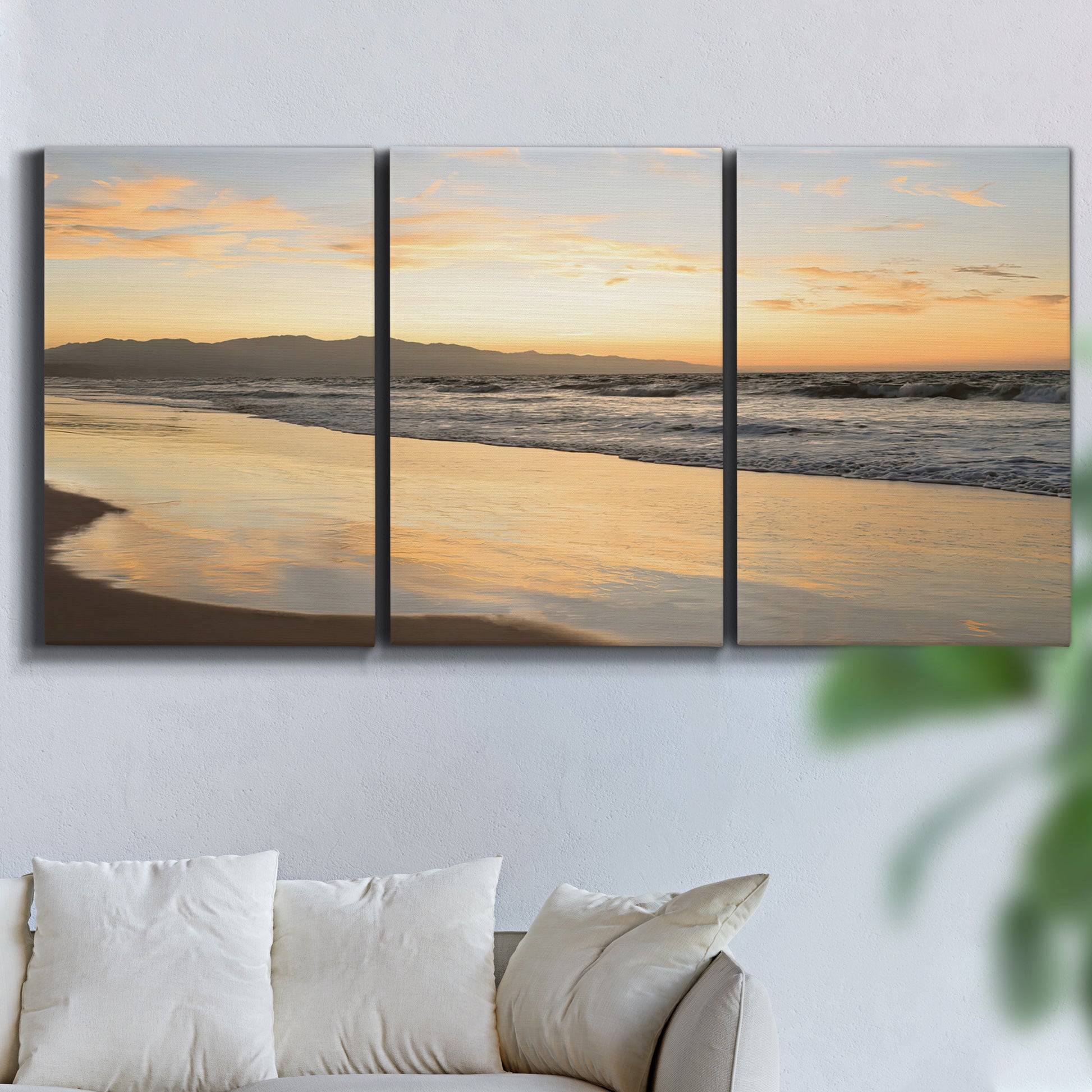 Three-panel canvas wall art featuring quiet tropical shoreline at low tide, displayed in a living room above a sofa.