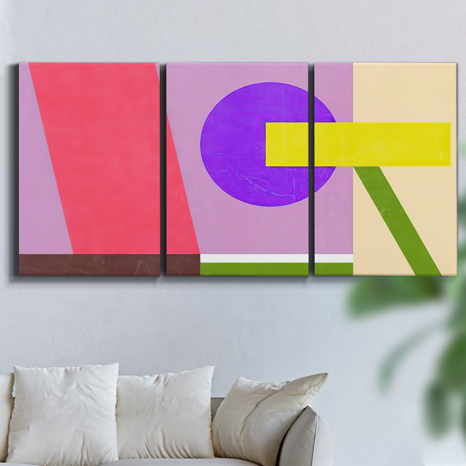 Three-panel canvas wall art featuring bold geometric color abstraction, displayed in a living room above a sofa.