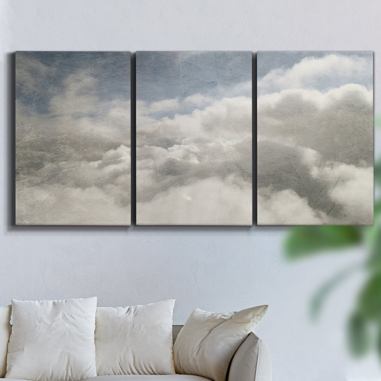 Three-panel canvas wall art featuring aerial landscape view photograph, displayed in a living room above a sofa.