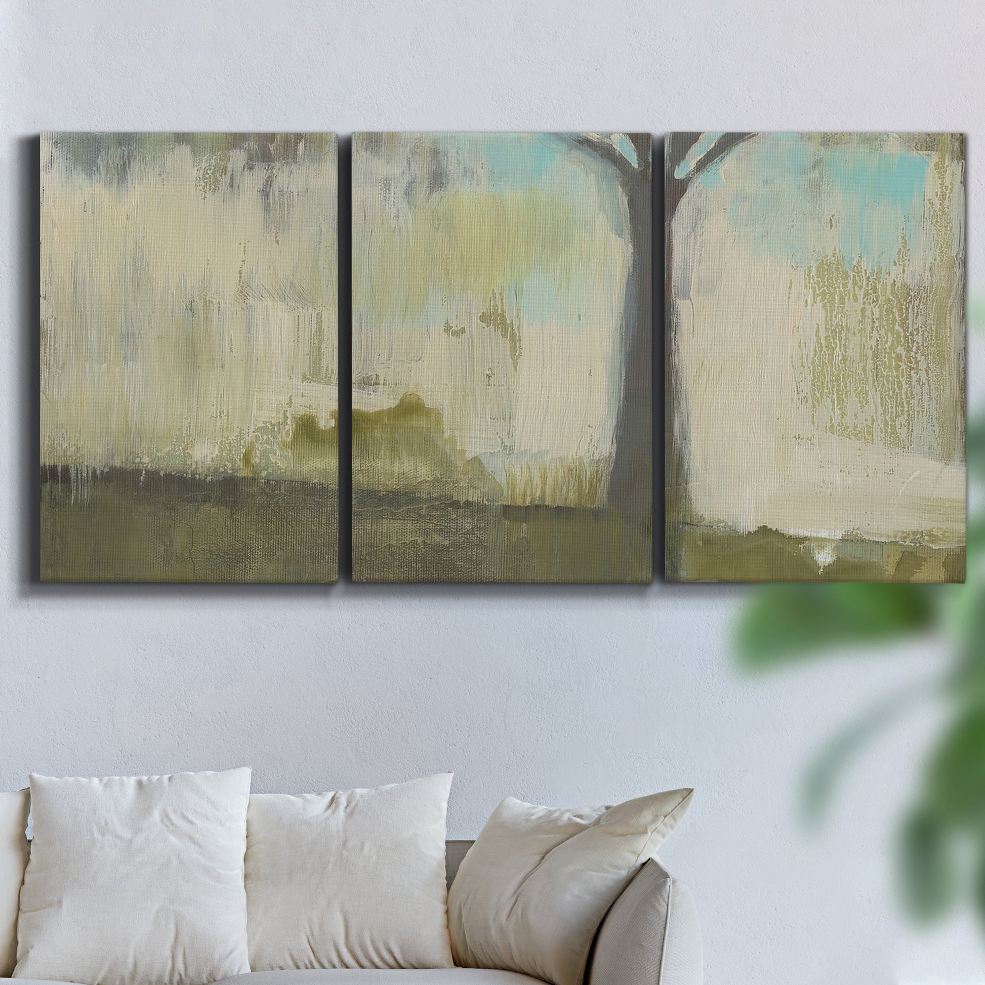 Three-panel canvas wall art featuring tall abstract tree form, displayed in a living room above a sofa.