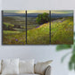 Three-panel canvas wall art featuring winding path through rolling hills, displayed in a living room above a sofa.