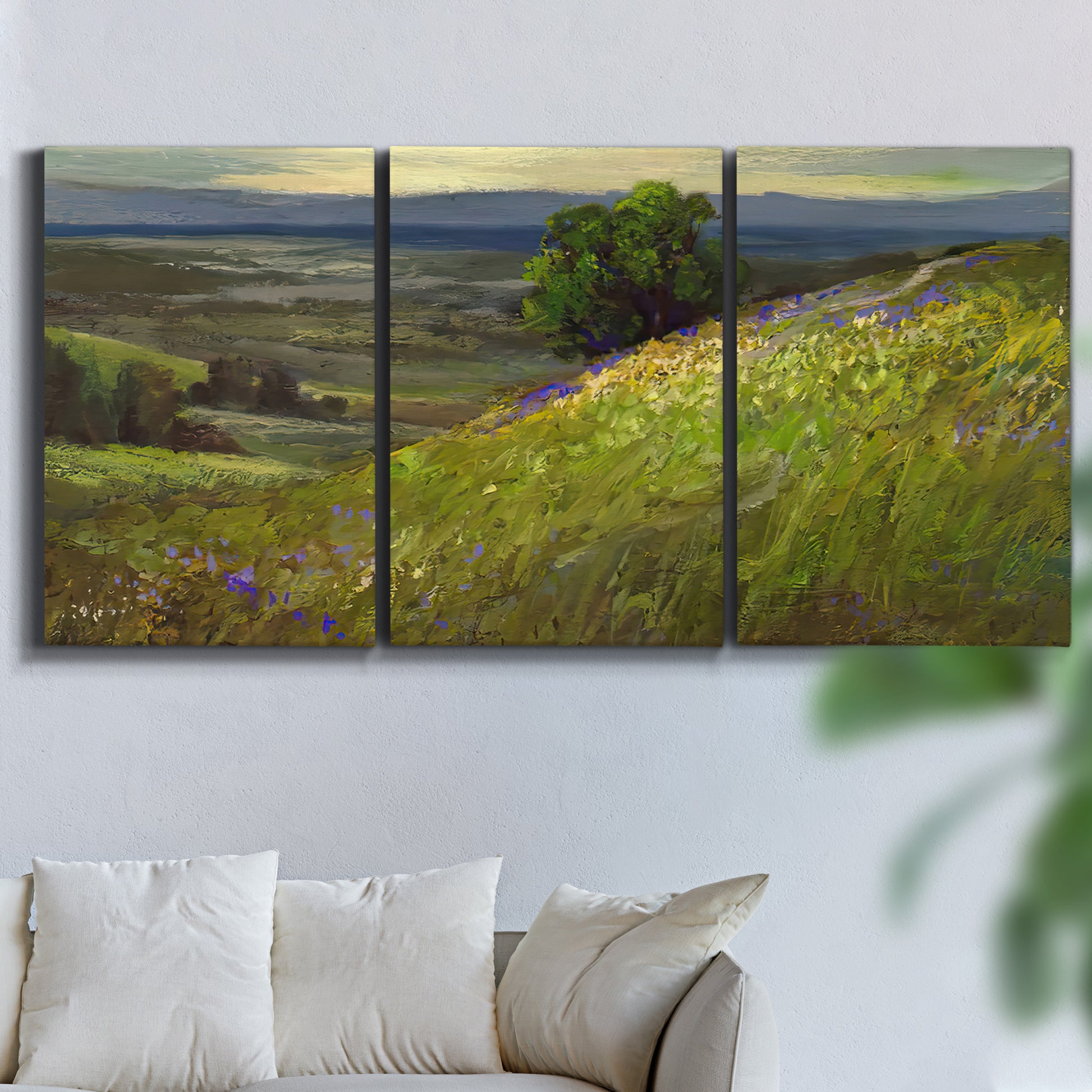 Three-panel canvas wall art featuring winding path through rolling hills, displayed in a living room above a sofa.