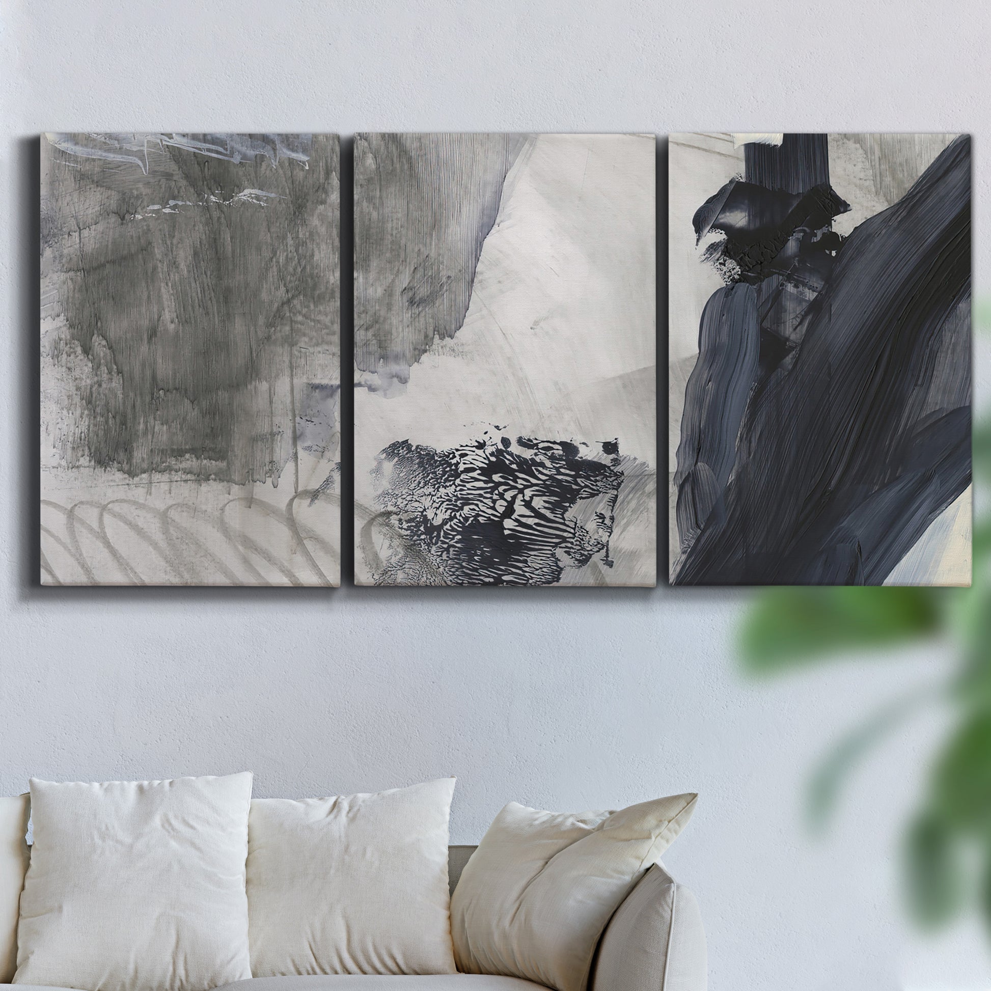 Three-panel canvas wall art featuring dark abstract atmospheric landscape, displayed in a living room above a sofa.