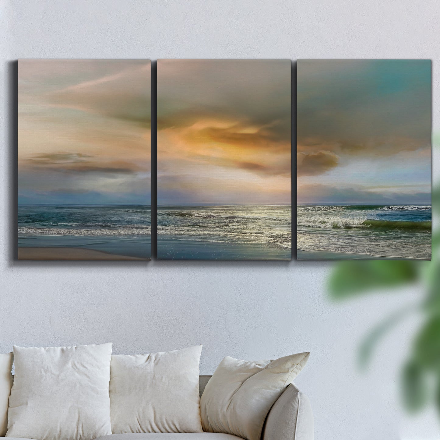 Three-panel canvas wall art featuring tranquil beach at sunset, displayed in a living room above a sofa.