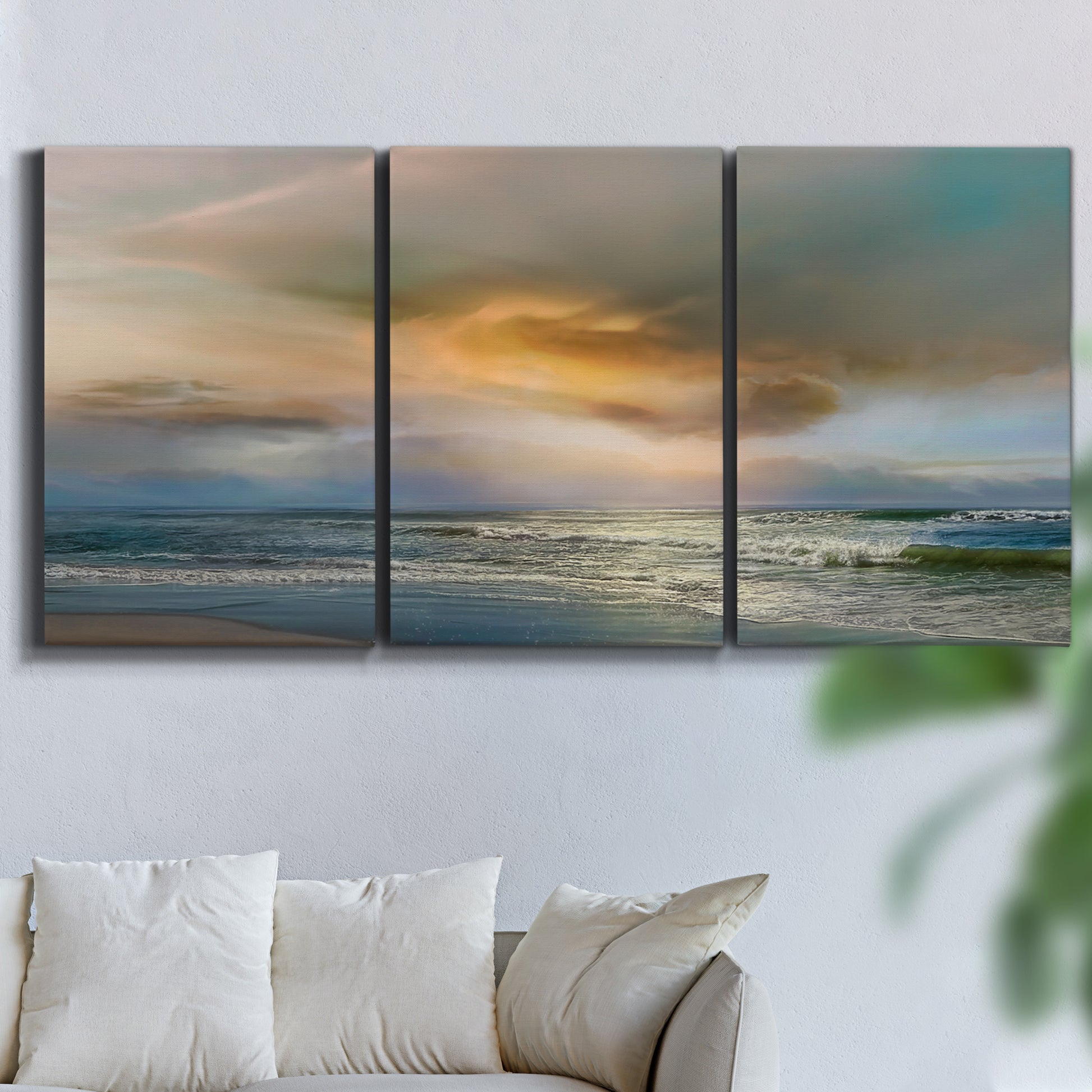 Three-panel canvas wall art featuring tranquil beach at sunset, displayed in a living room above a sofa.