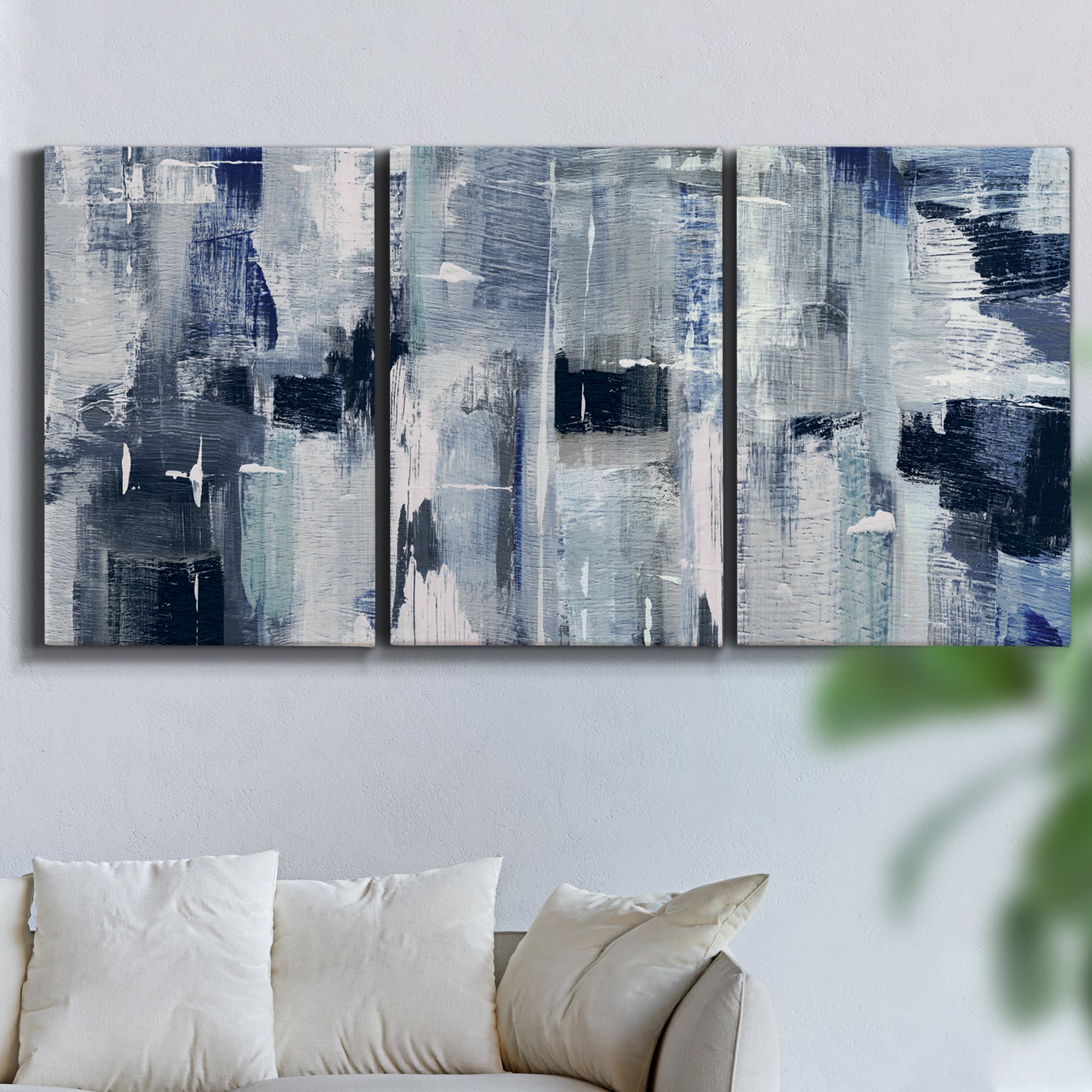 Three-panel canvas wall art featuring soft abstract mountain color fields, displayed in a living room above a sofa.