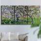 Three-panel canvas wall art featuring apple trees blooming beside water, displayed in a living room above a sofa.