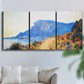 Three-panel canvas wall art featuring winding red road hillside, displayed in a living room above a sofa.