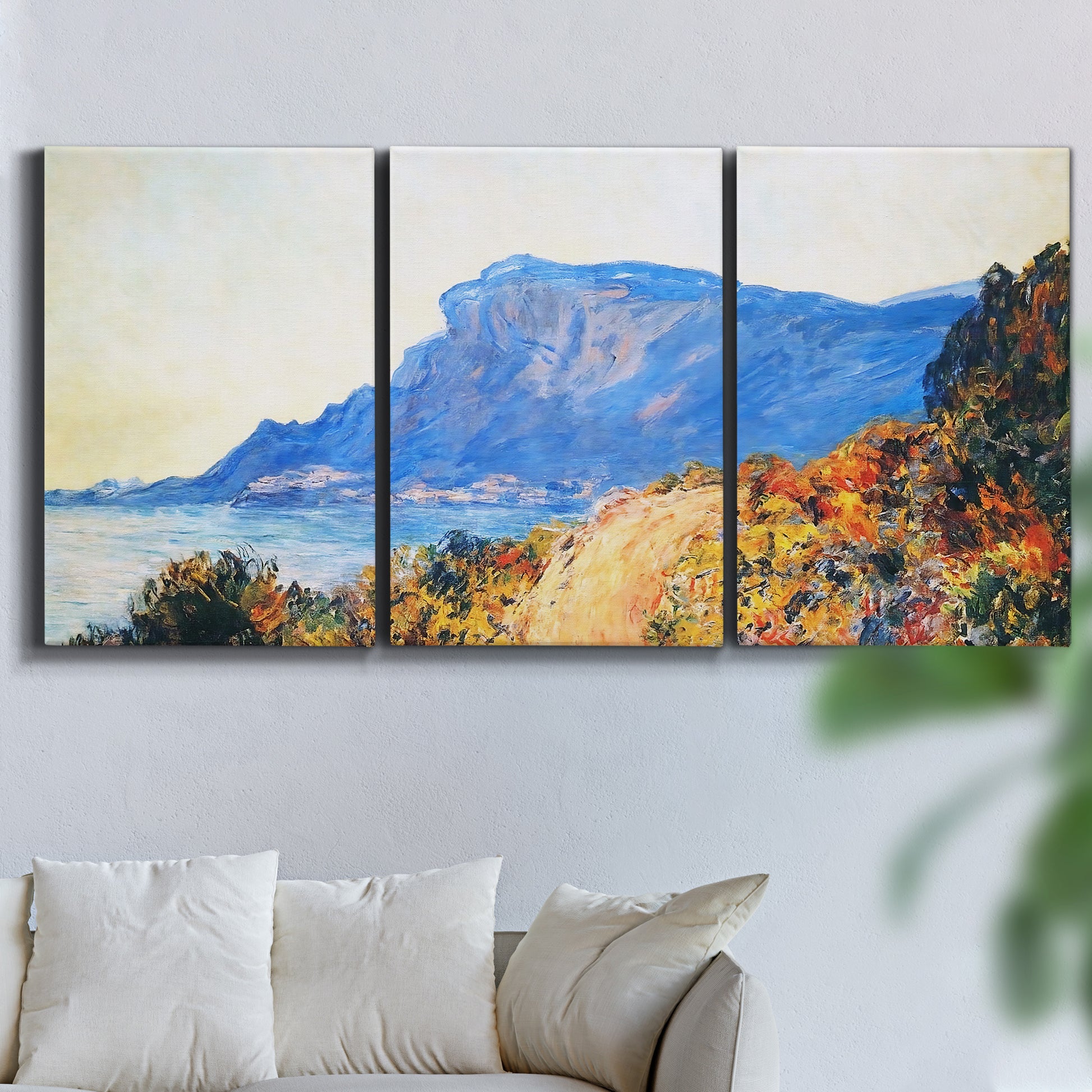 Three-panel canvas wall art featuring winding red road hillside, displayed in a living room above a sofa.