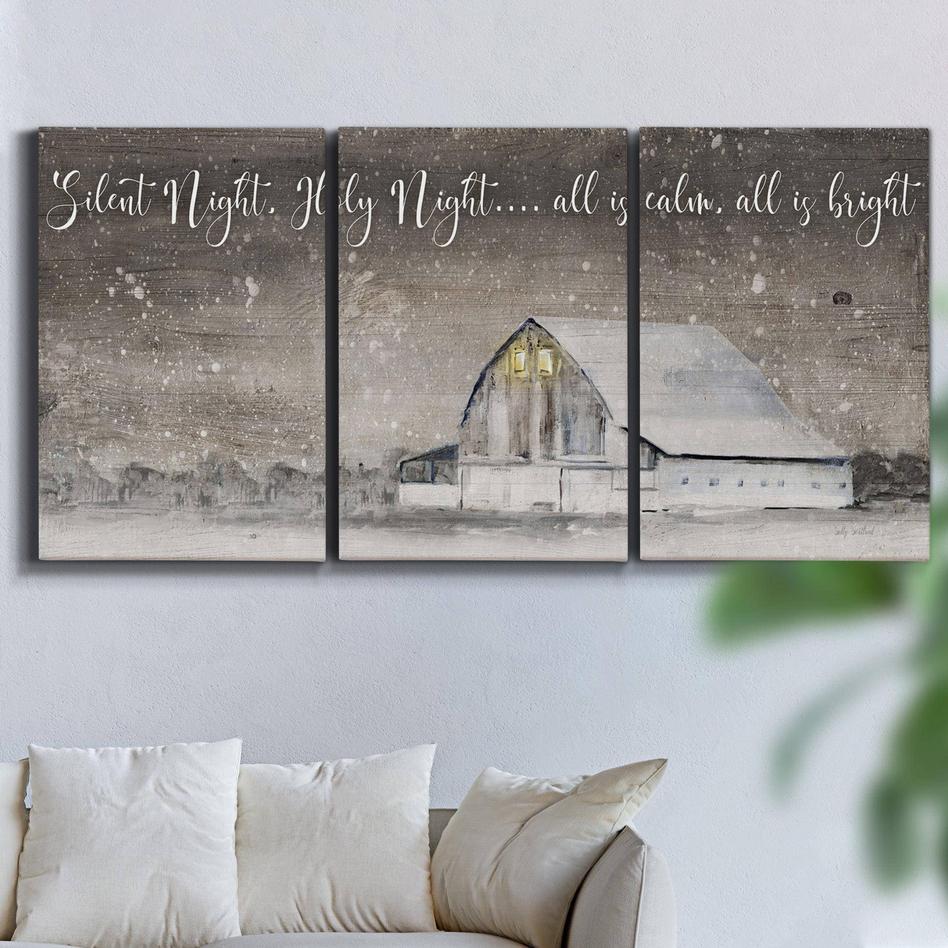 Three-panel canvas wall art featuring rustic winter holiday text art, displayed in a living room above a sofa.