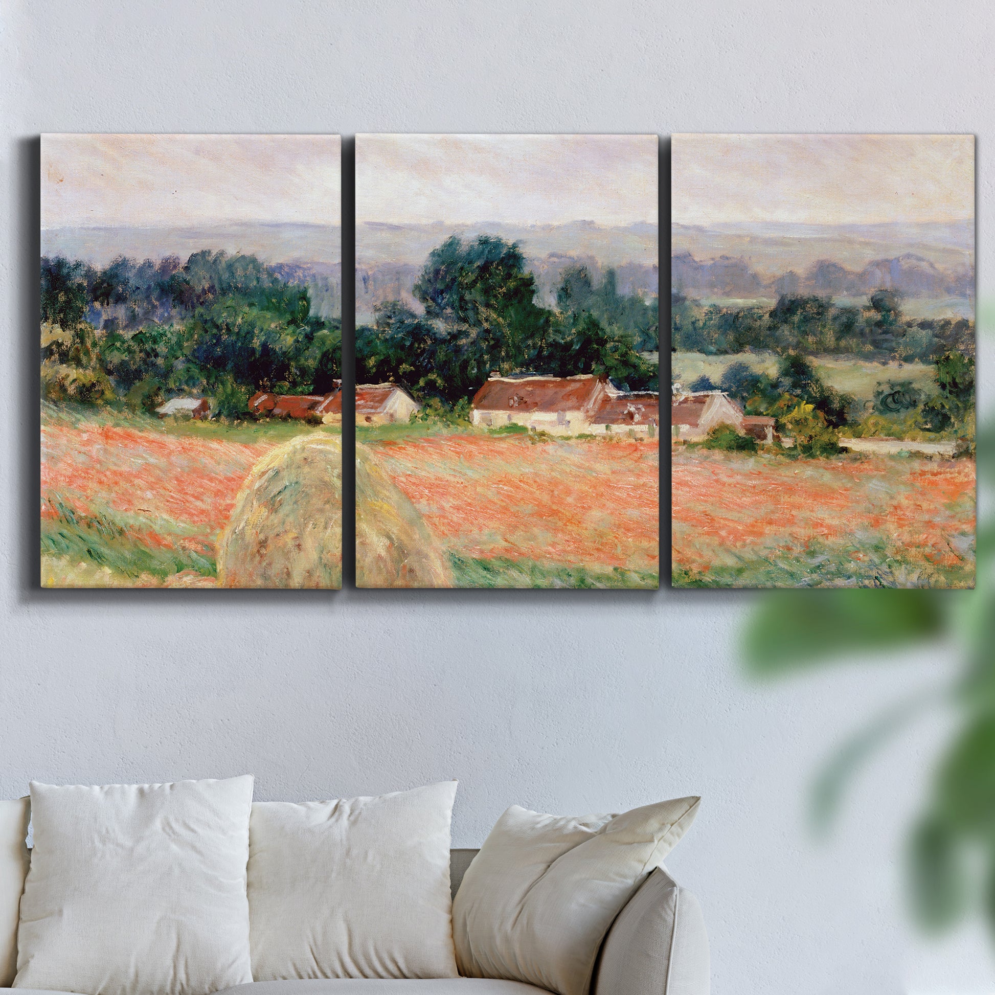 Three-panel canvas wall art featuring haystacks arranged in rural field, displayed in a living room above a sofa.