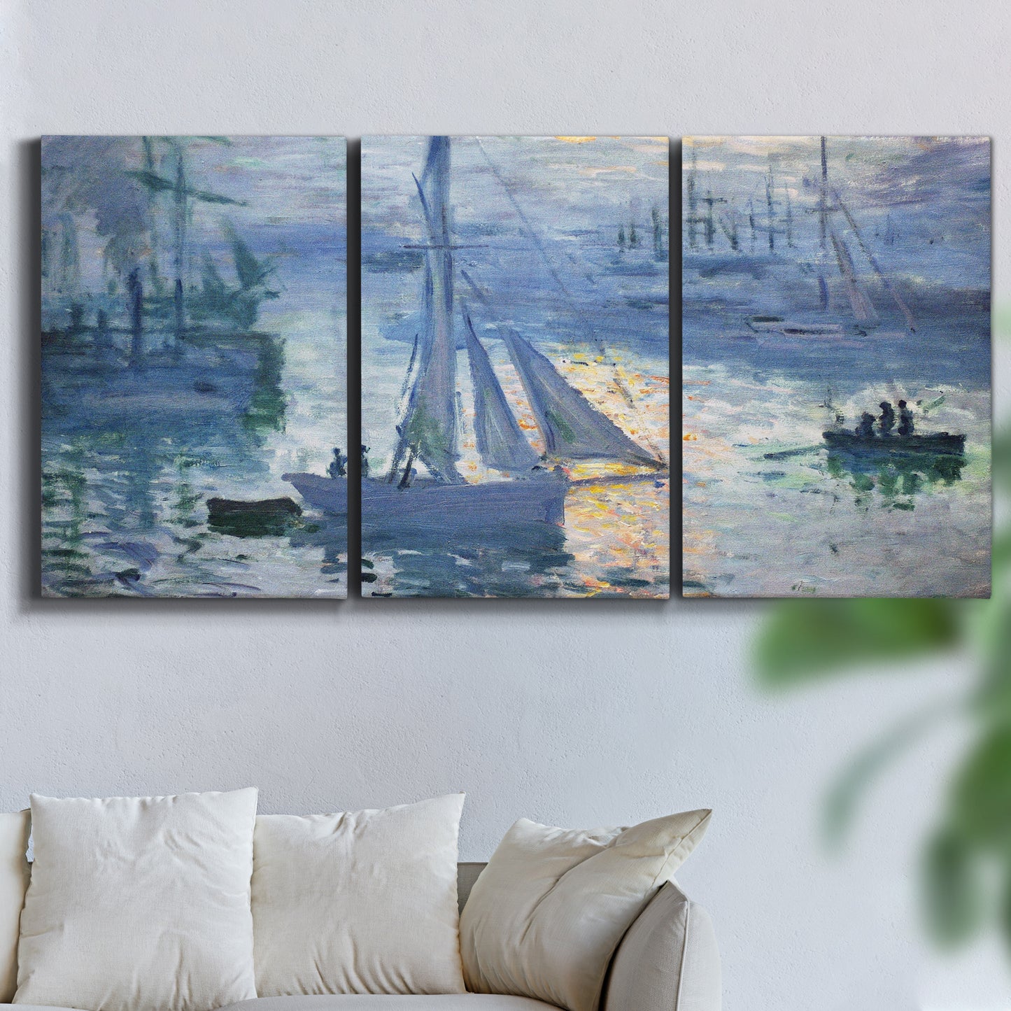 Three-panel canvas wall art featuring sailboats racing on river, displayed in a living room above a sofa.