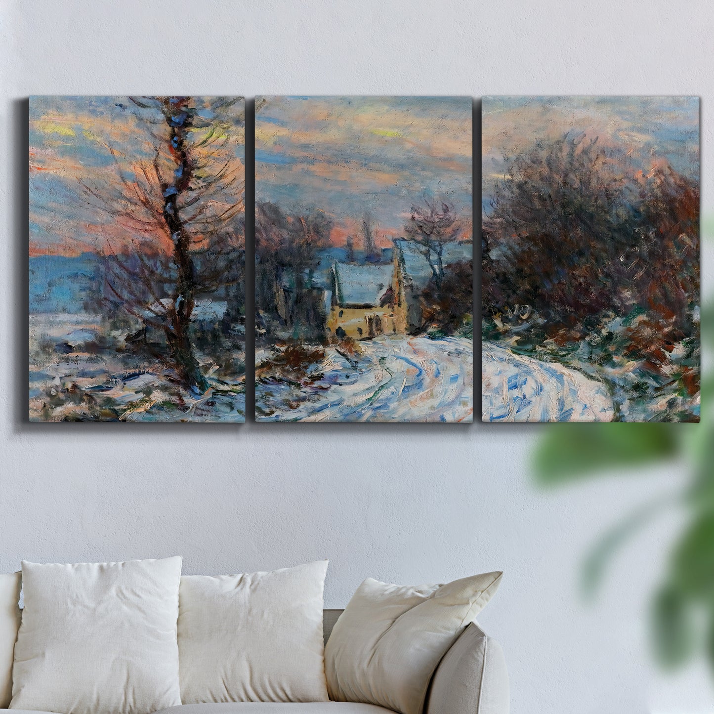 Three-panel canvas wall art featuring snow covered road leading to village, displayed in a living room above a sofa.
