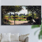 Three-panel canvas wall art featuring coastal garden overlooking sea, displayed in a living room above a sofa.