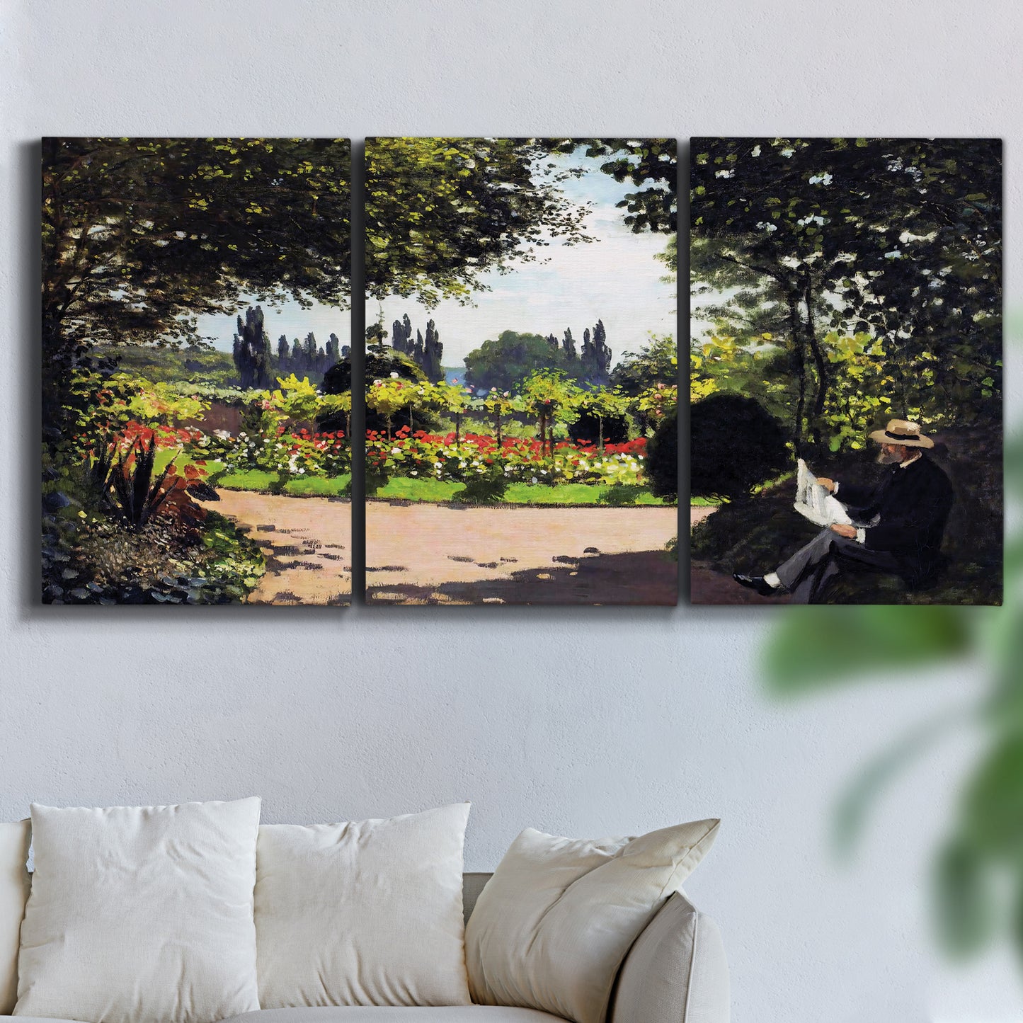 Three-panel canvas wall art featuring coastal garden overlooking sea, displayed in a living room above a sofa.