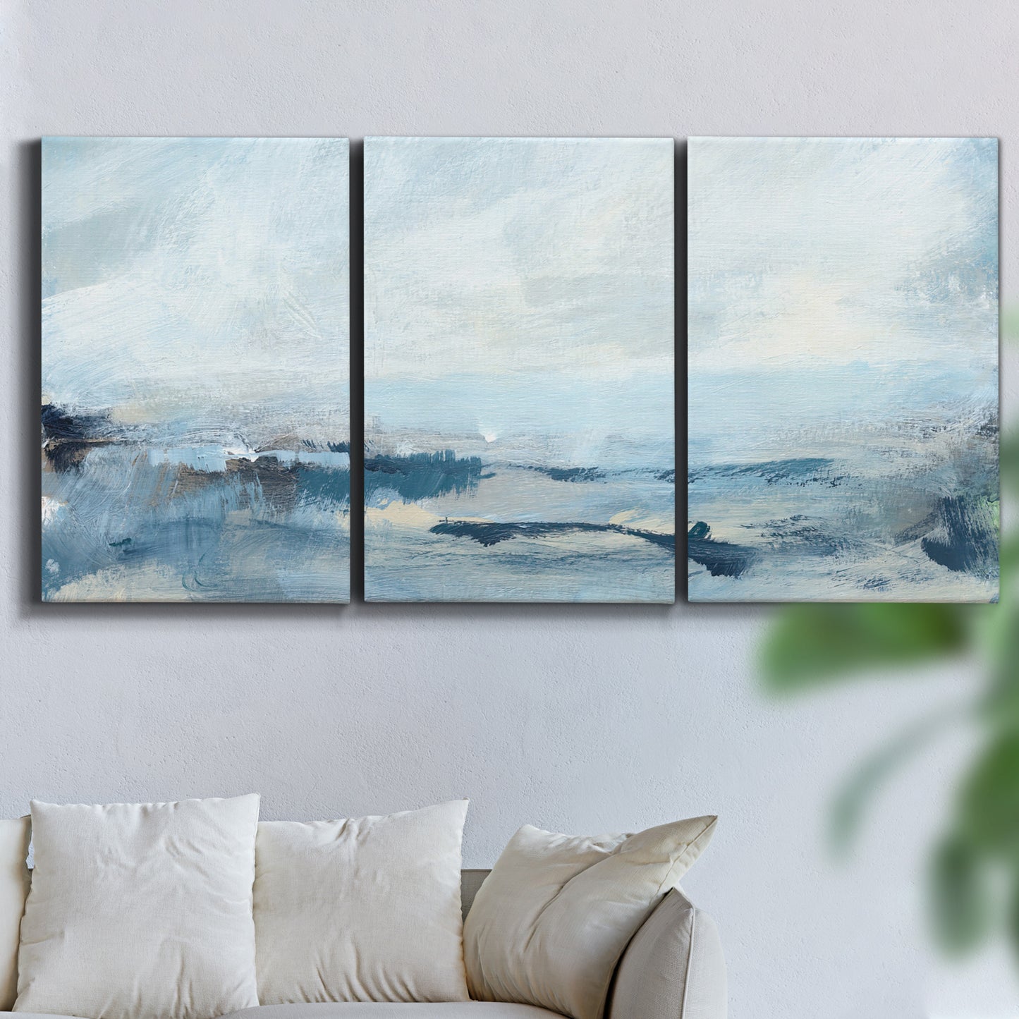 Three-panel canvas wall art featuring abstract sailboats on water, displayed in a living room above a sofa.