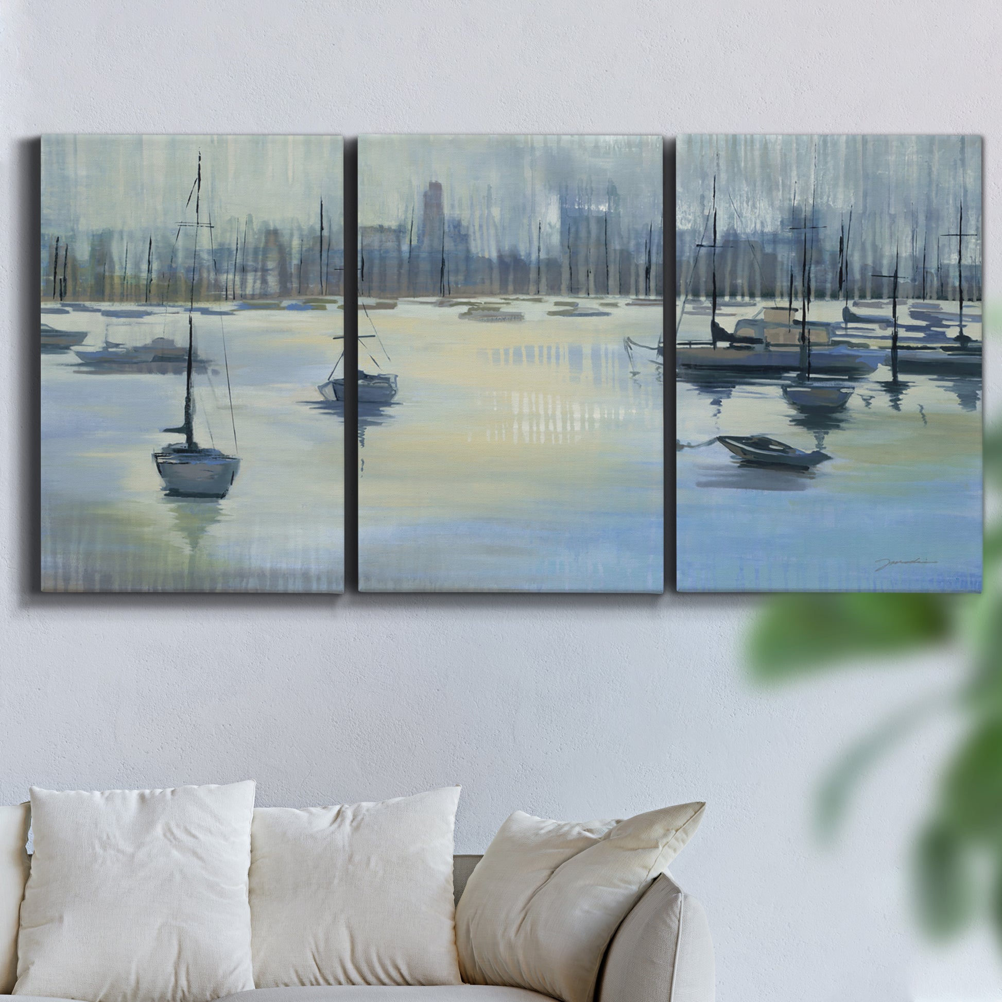 Three-panel canvas wall art featuring anchored boats near shoreline, displayed in a living room above a sofa.