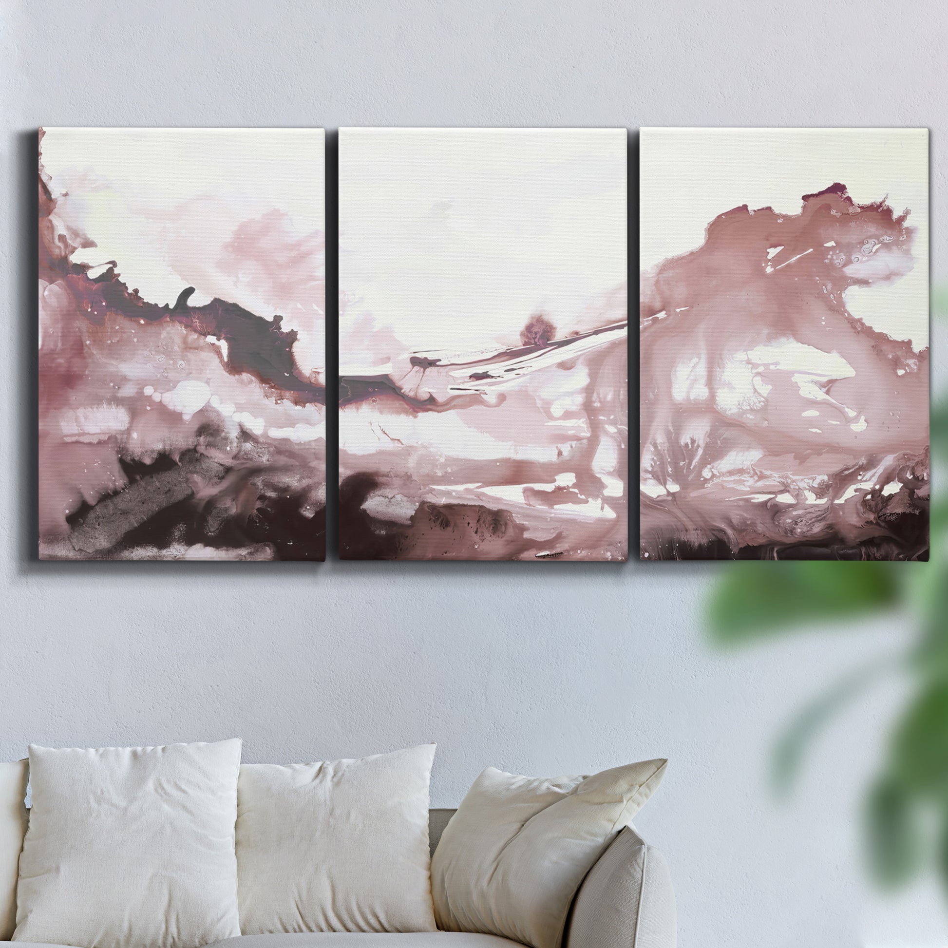 Three-panel canvas wall art featuring soft pink abstract scenic layers, displayed in a living room above a sofa.