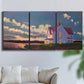 Three-panel canvas wall art featuring farmhouse scene before approaching storm, displayed in a living room above a sofa.
