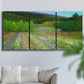 Three-panel canvas wall art featuring fresh spring meadow landscape, displayed in a living room above a sofa.