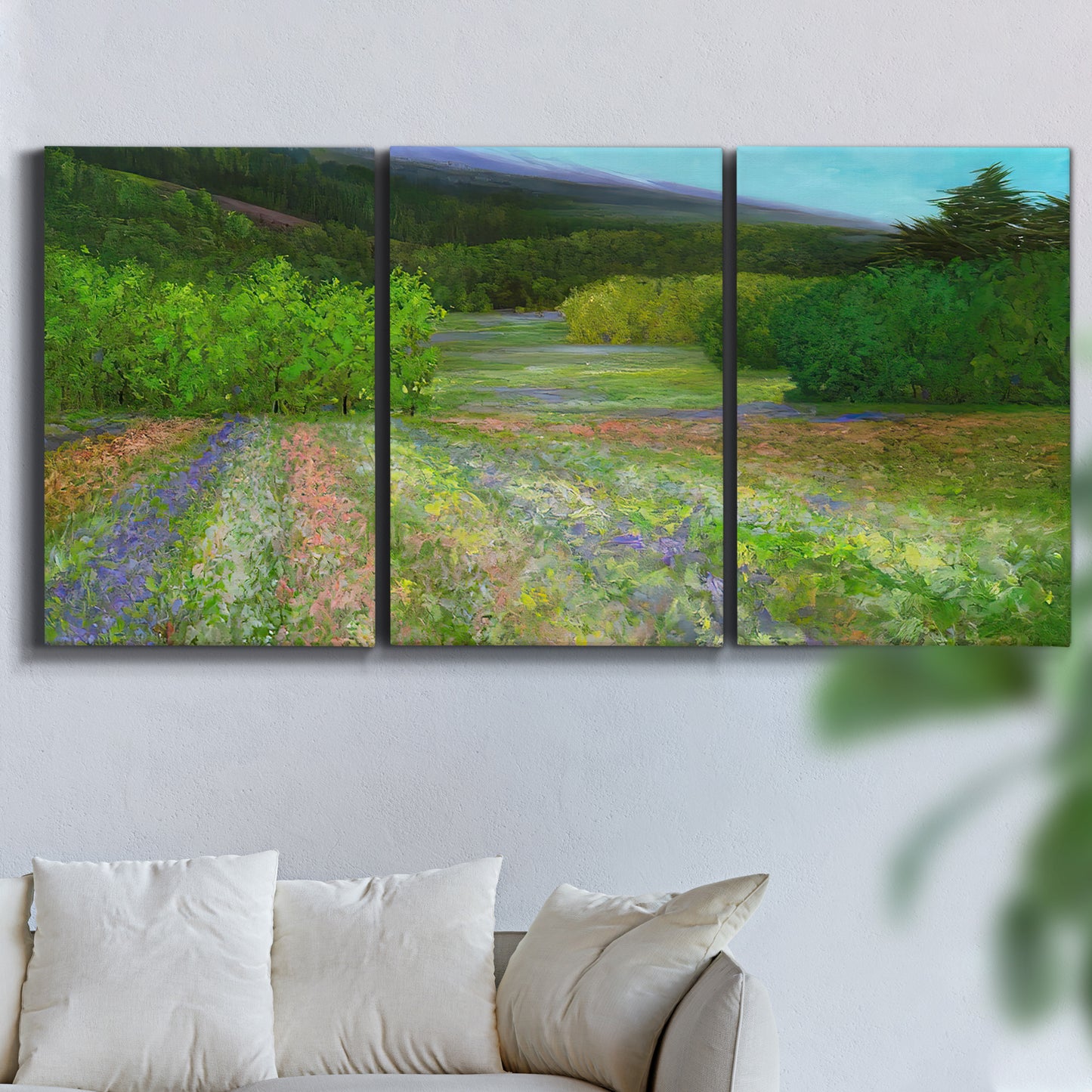 Three-panel canvas wall art featuring fresh spring meadow landscape, displayed in a living room above a sofa.