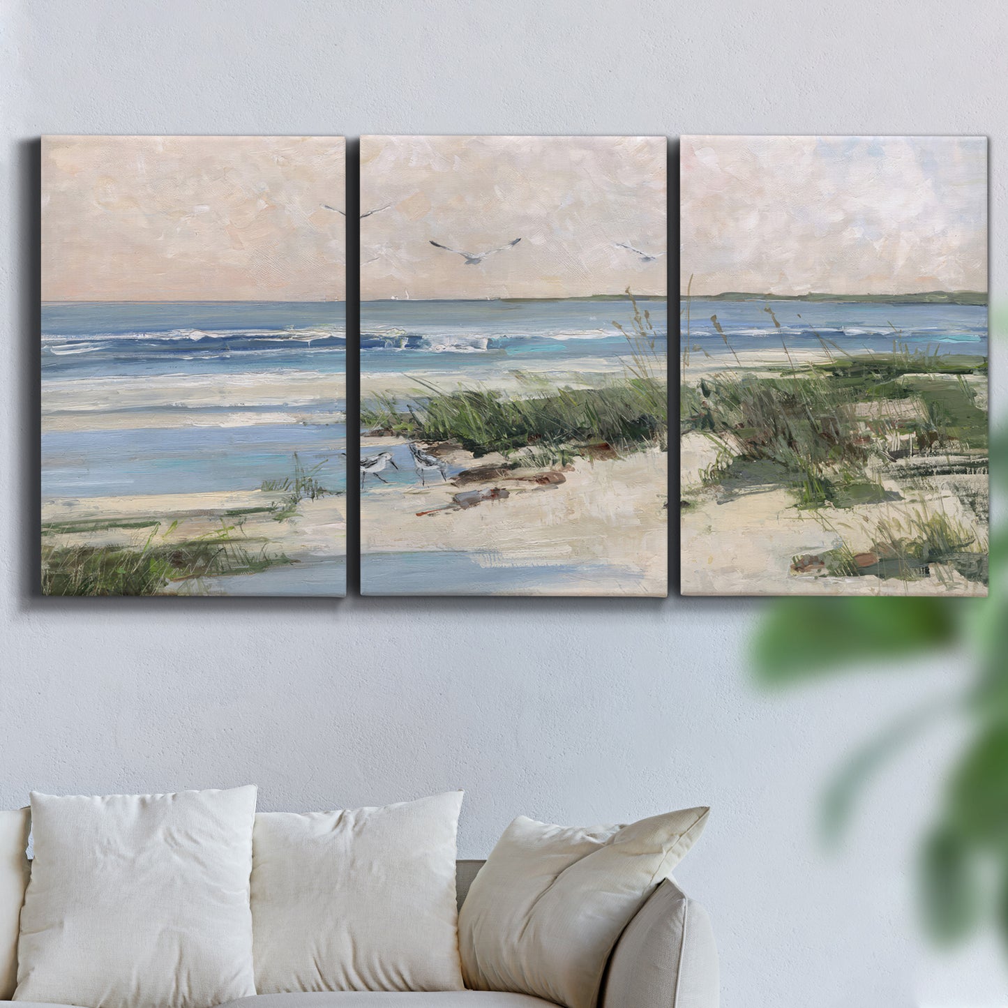 Three-panel canvas wall art featuring soft morning light over calm sea, displayed in a living room above a sofa.