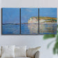 Three-panel canvas wall art featuring white cliffs rising above sea, displayed in a living room above a sofa.