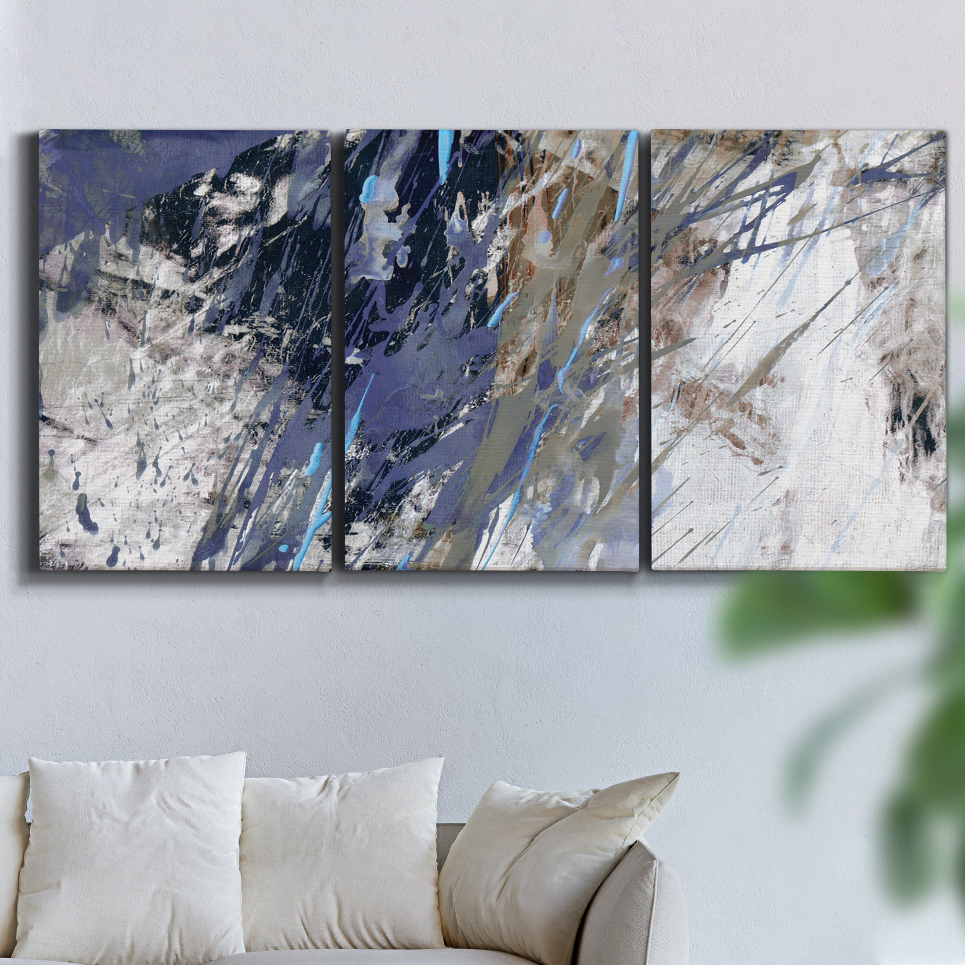 Three-panel canvas wall art featuring textured blue abstract composition, displayed in a living room above a sofa.