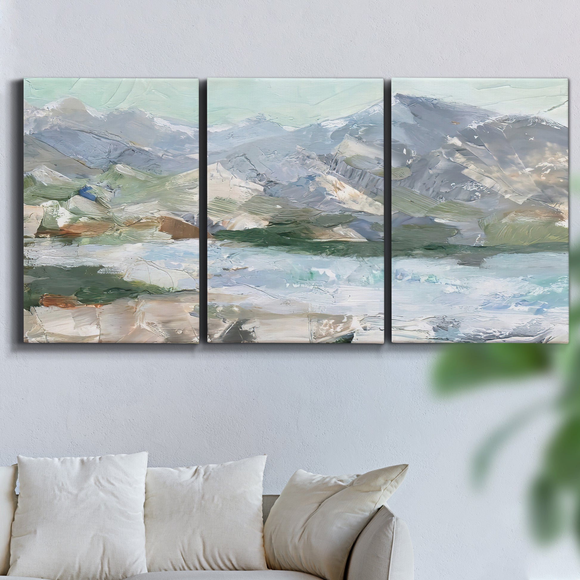 Three-panel canvas wall art featuring pastel mountain landscape view, displayed in a living room above a sofa.