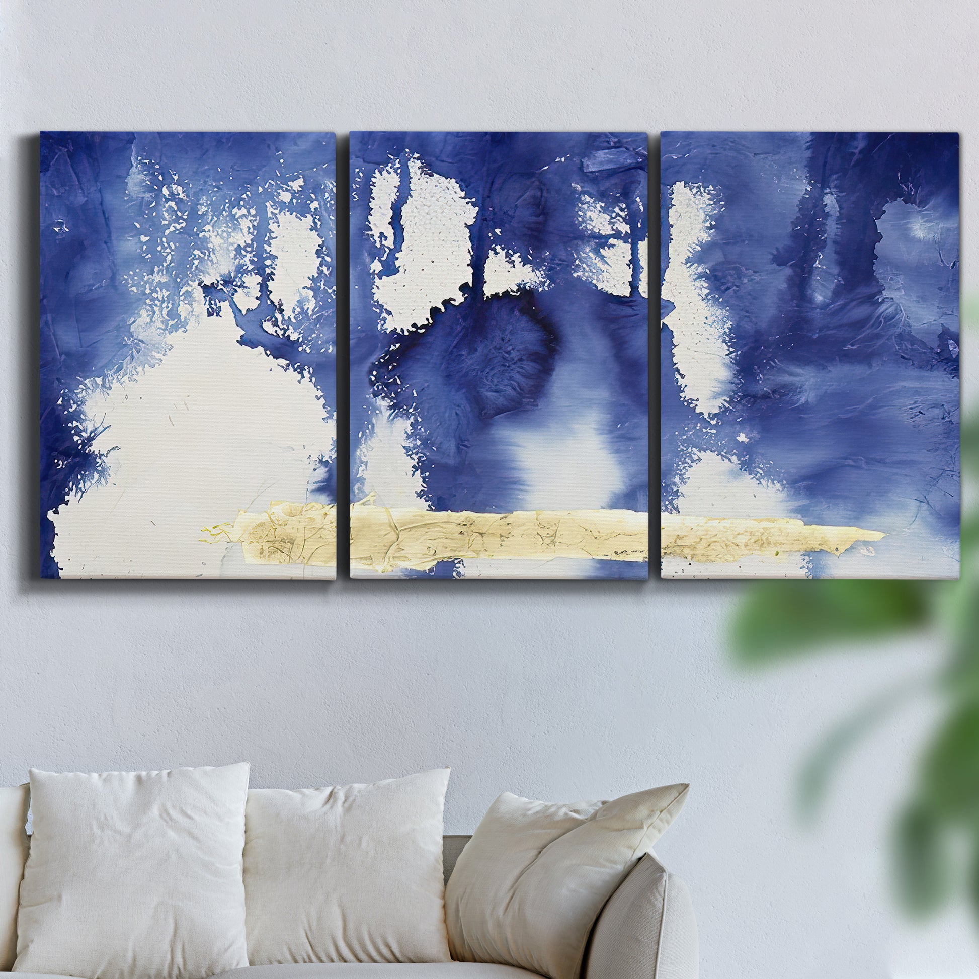 Three-panel canvas wall art featuring saturated abstract color fields, displayed in a living room above a sofa.
