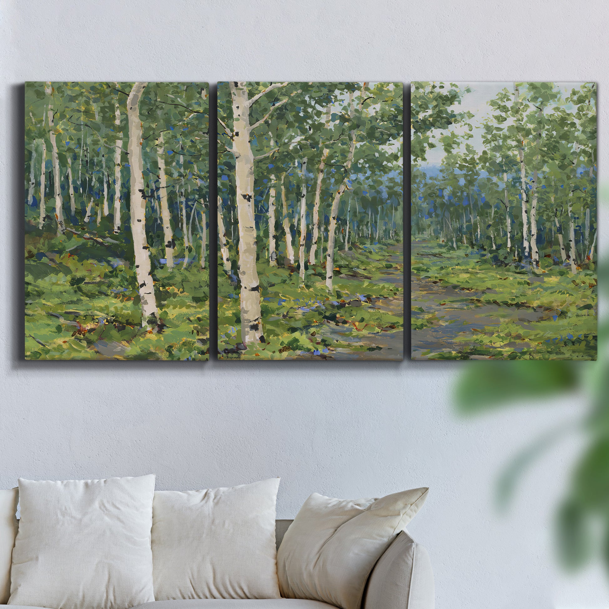 Three-panel canvas wall art featuring woodland forest scene with tall trees, displayed in a living room above a sofa.
