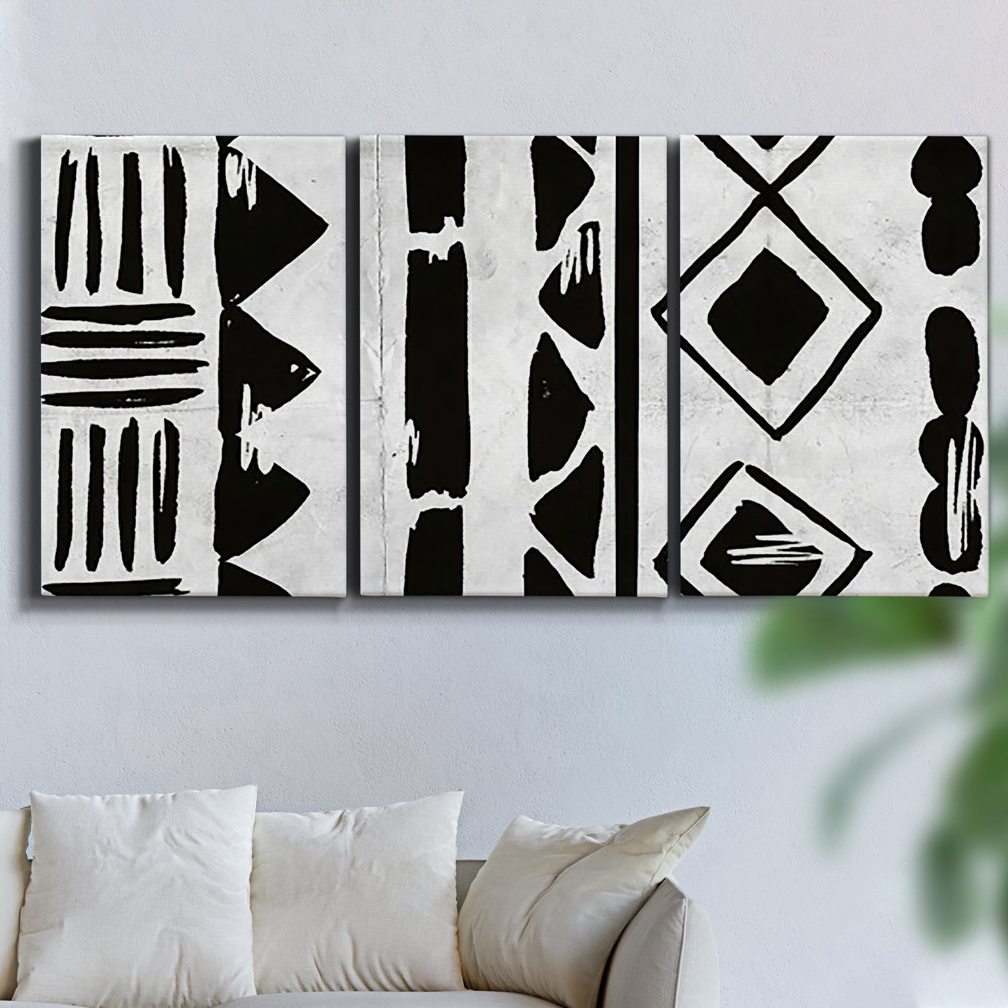 Three-panel canvas wall art featuring geometric abstract forms merging pattern, displayed in a living room above a sofa.