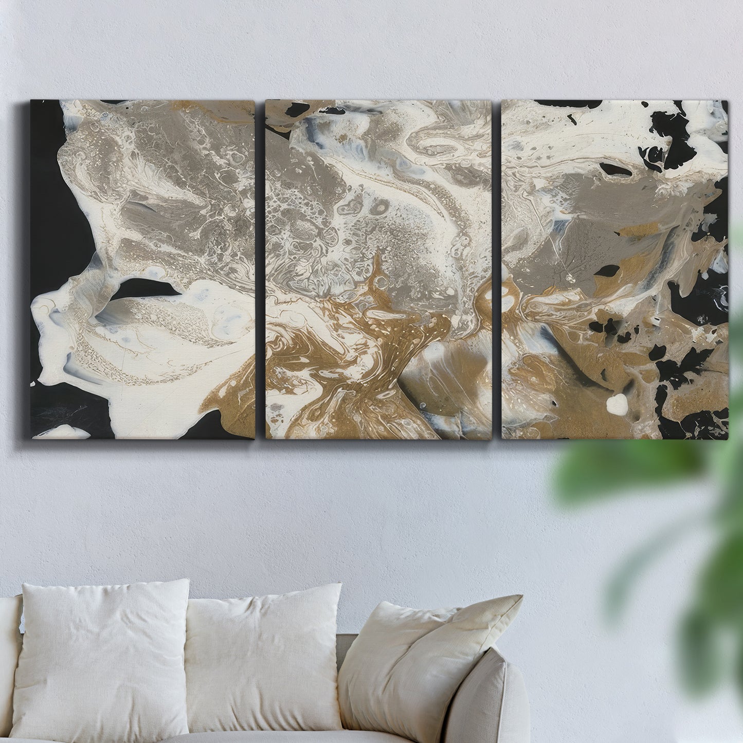 Three-panel canvas wall art featuring pale abstract mask like forms, displayed in a living room above a sofa.