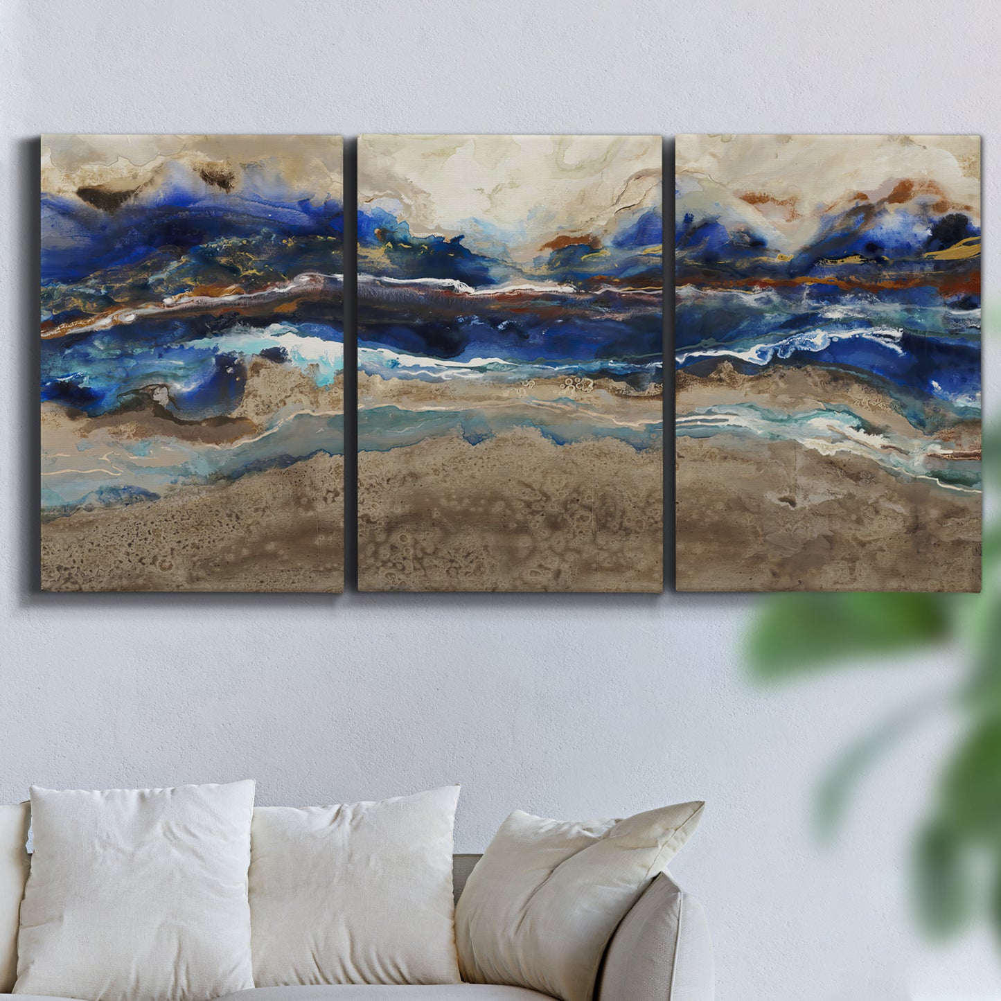 Three-panel canvas wall art featuring abstract coastal jewel toned composition, displayed in a living room above a sofa.