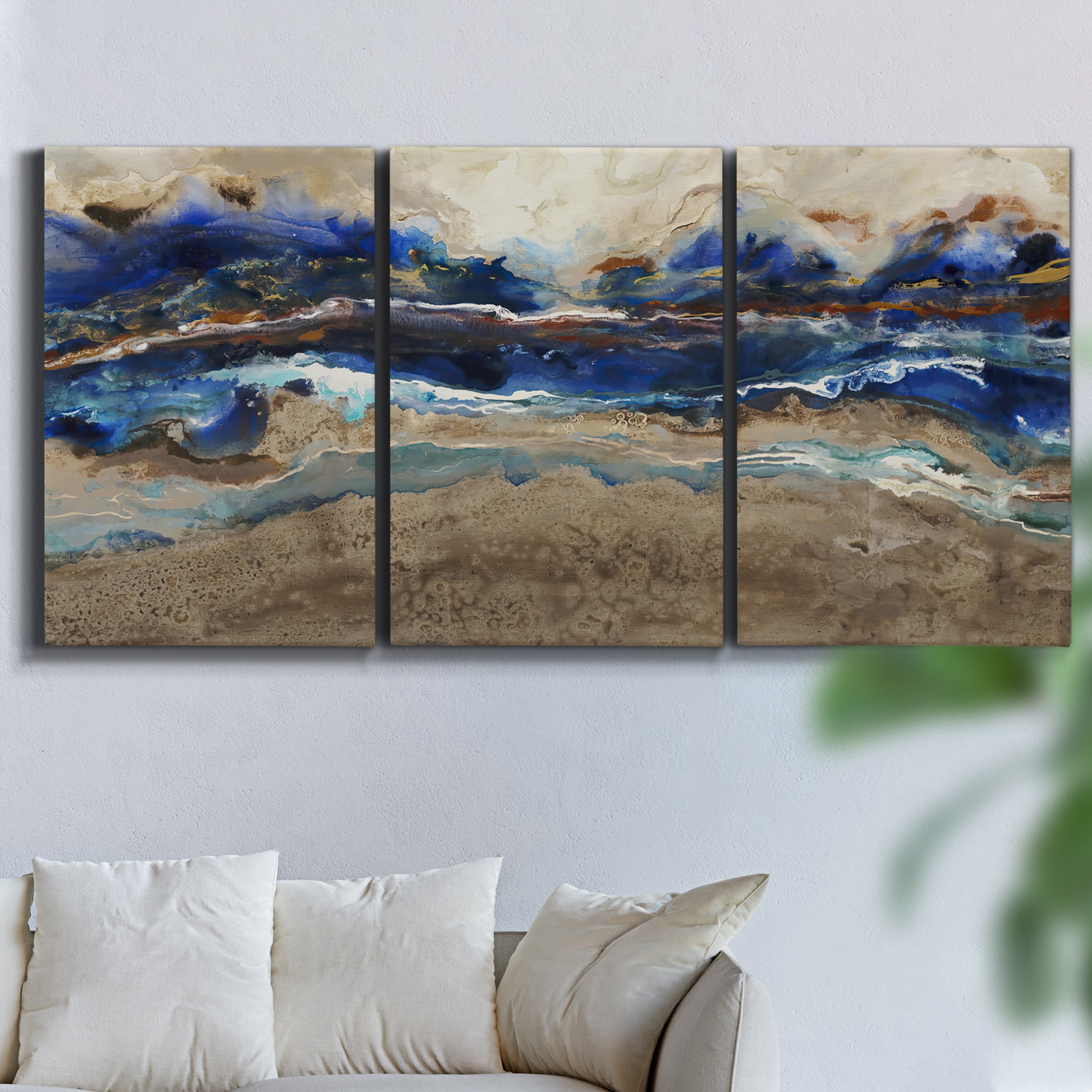 Three-panel canvas wall art featuring abstract coastal jewel toned composition, displayed in a living room above a sofa.