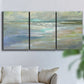 Three-panel canvas wall art featuring soft coastal beach light landscape, displayed in a living room above a sofa.