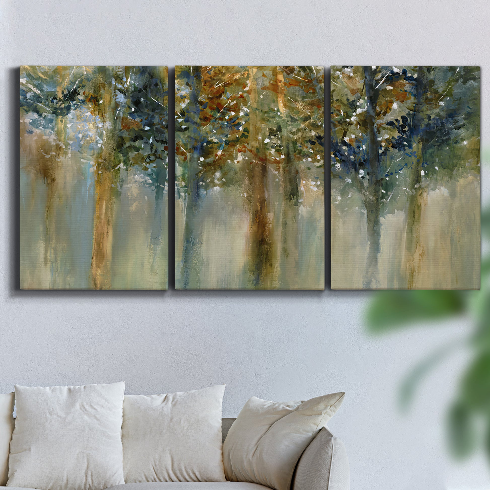Three-panel canvas wall art featuring earth toned abstract leaf textures, displayed in a living room above a sofa.