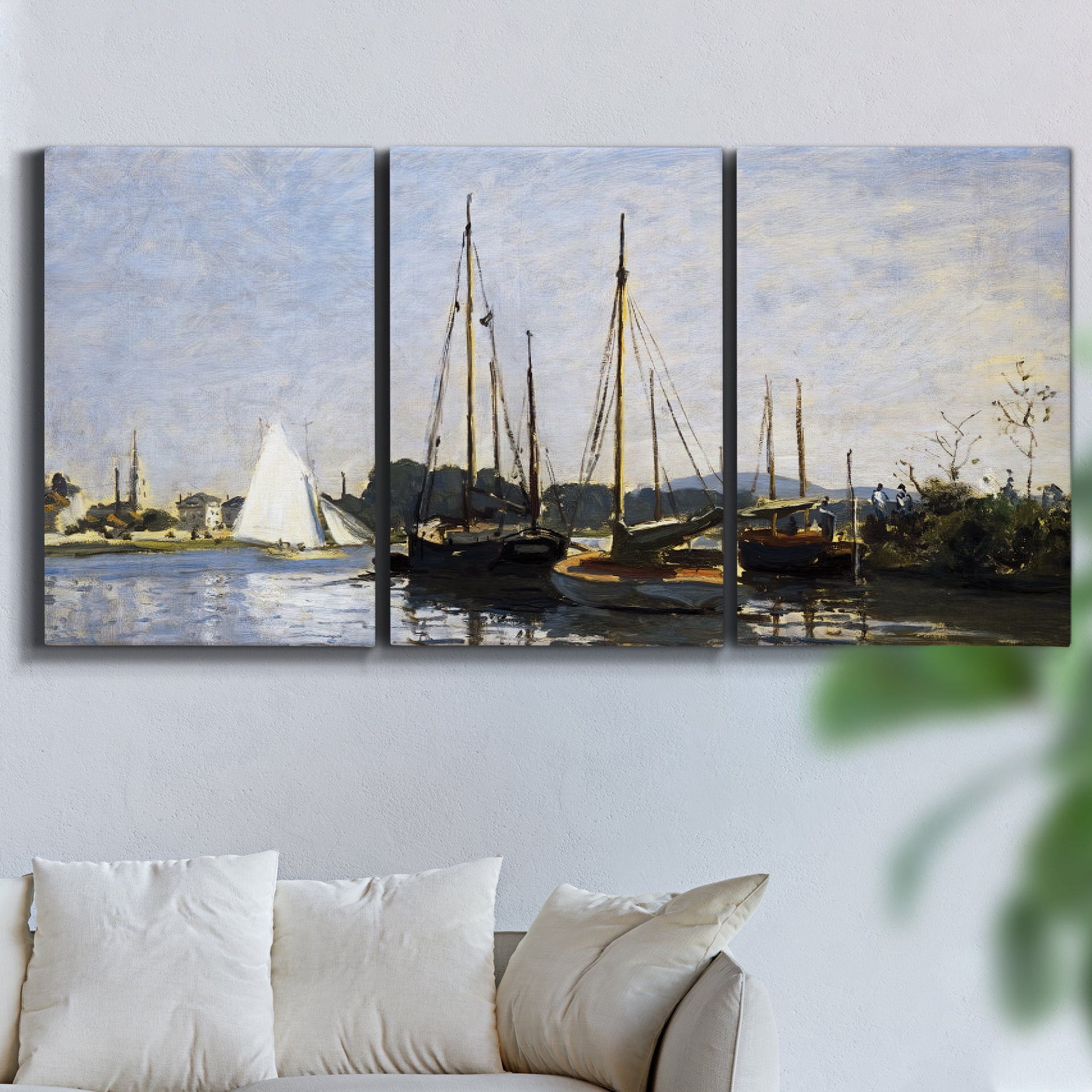 Three-panel canvas wall art featuring small pleasure boats on calm water, displayed in a living room above a sofa.